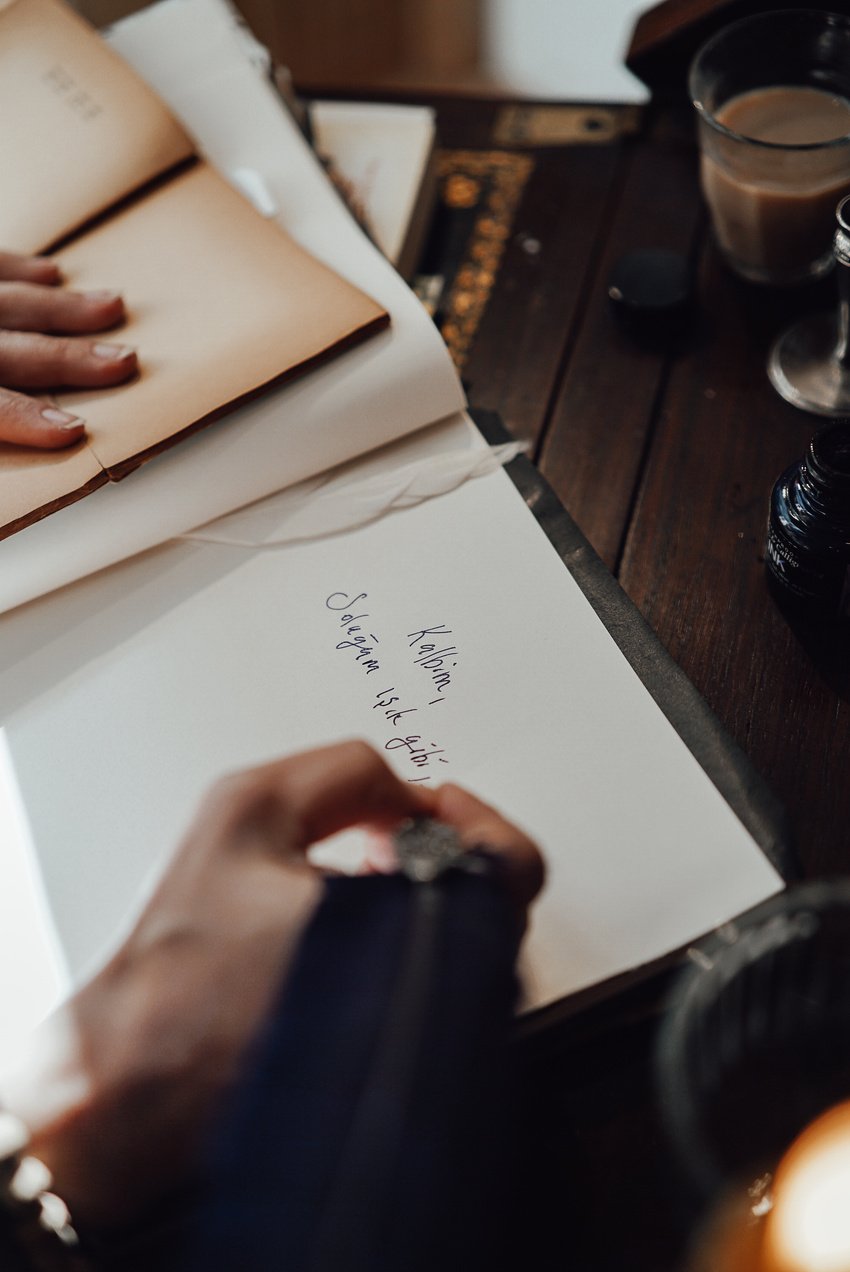 Crop anonymous author writing novel in notebook at home